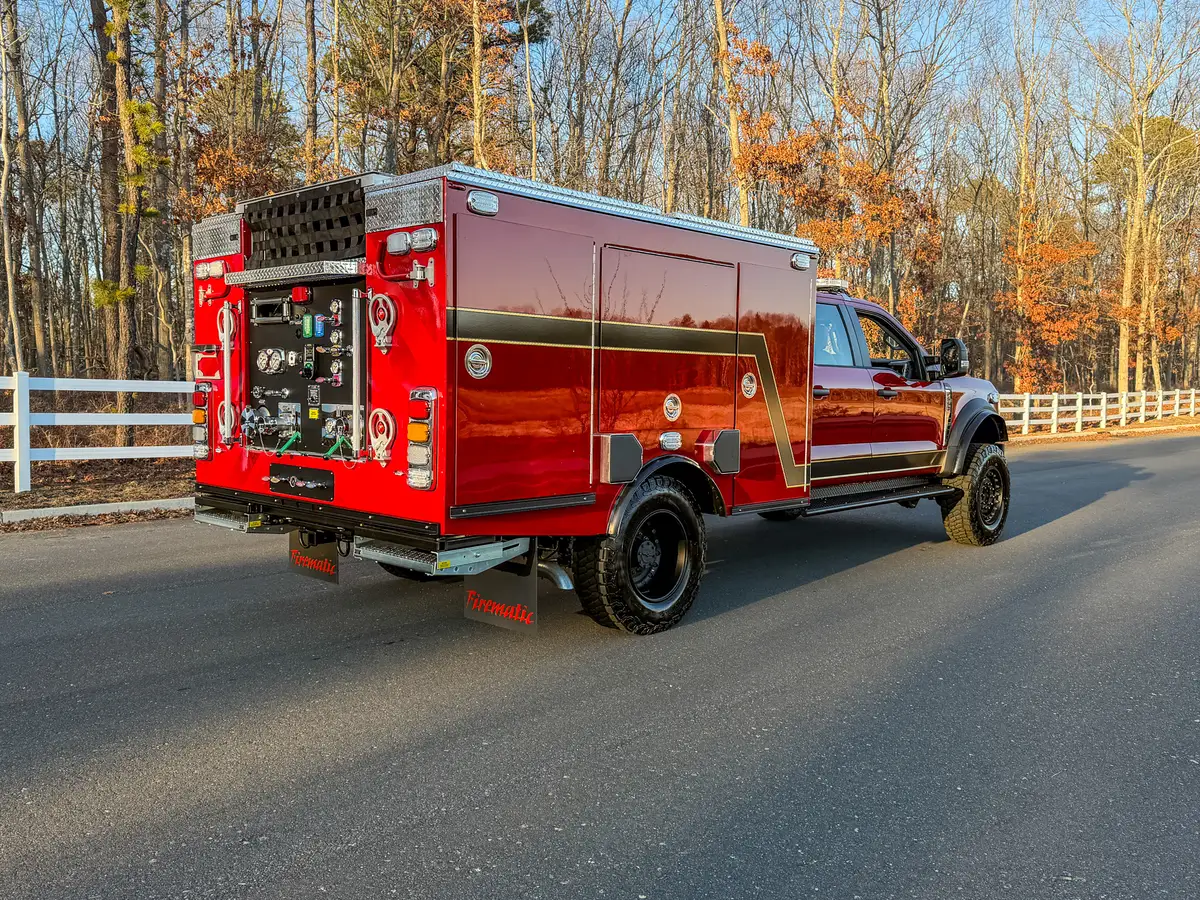 Rear three-quarter view of red brush truck with rear pump panel visible.