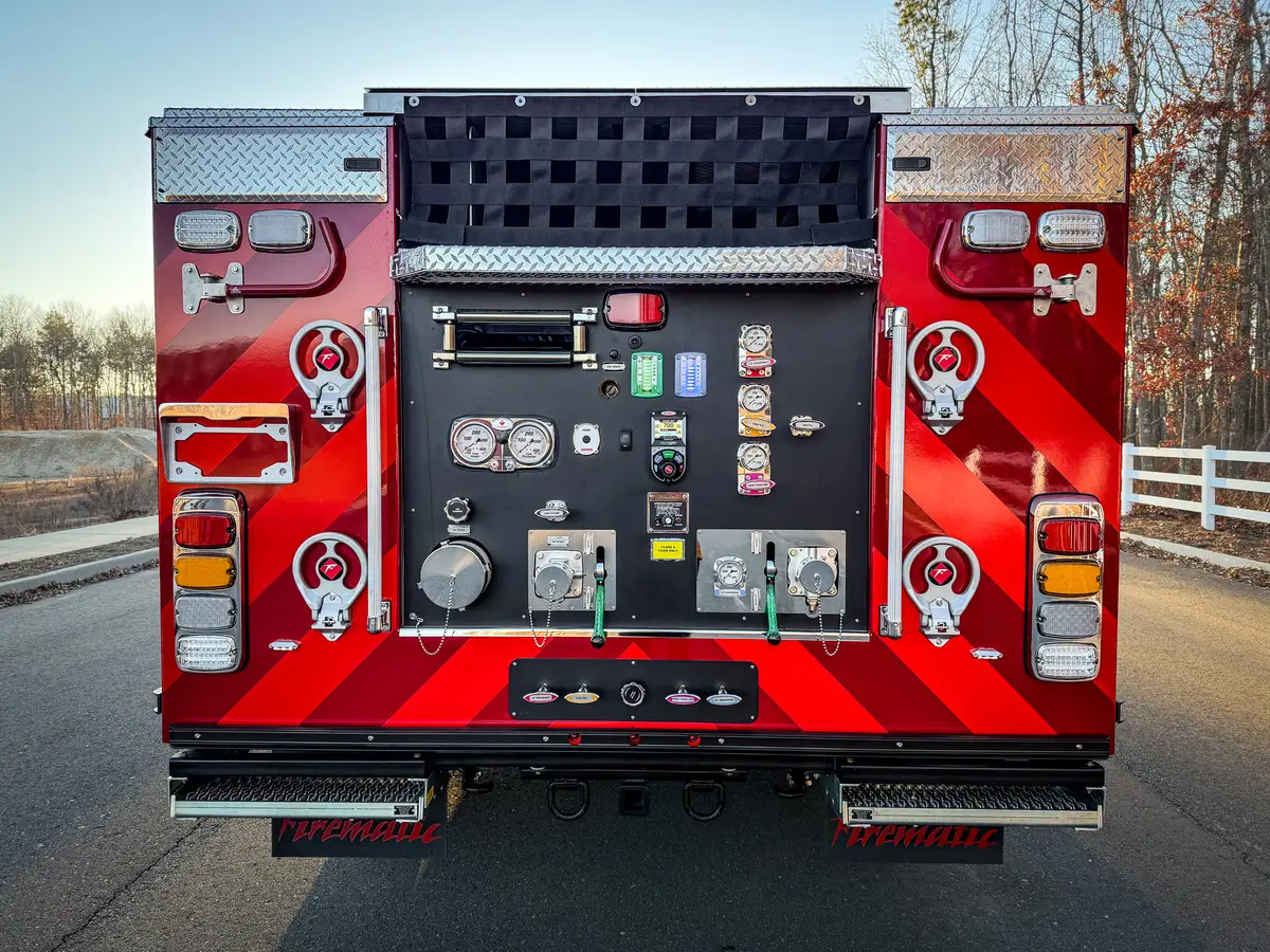 Straight rear view of pump panel with gauges, valves, and hose connections.