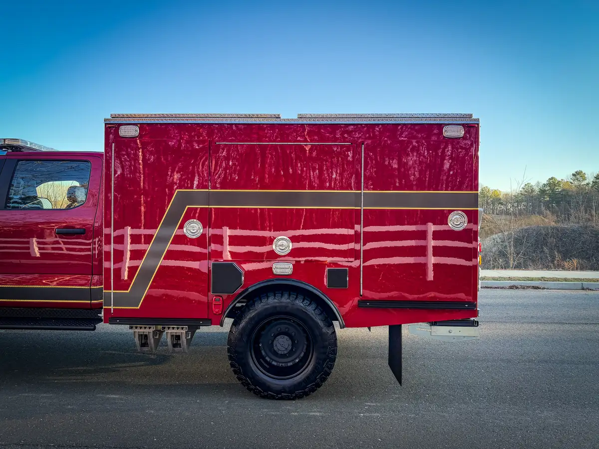 Right-side body close-up with compartment doors closed above rear wheel.