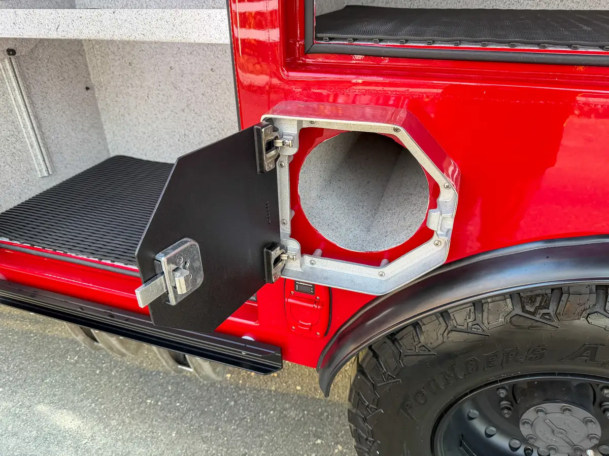 Open round utility port compartment near rear wheel and side step.