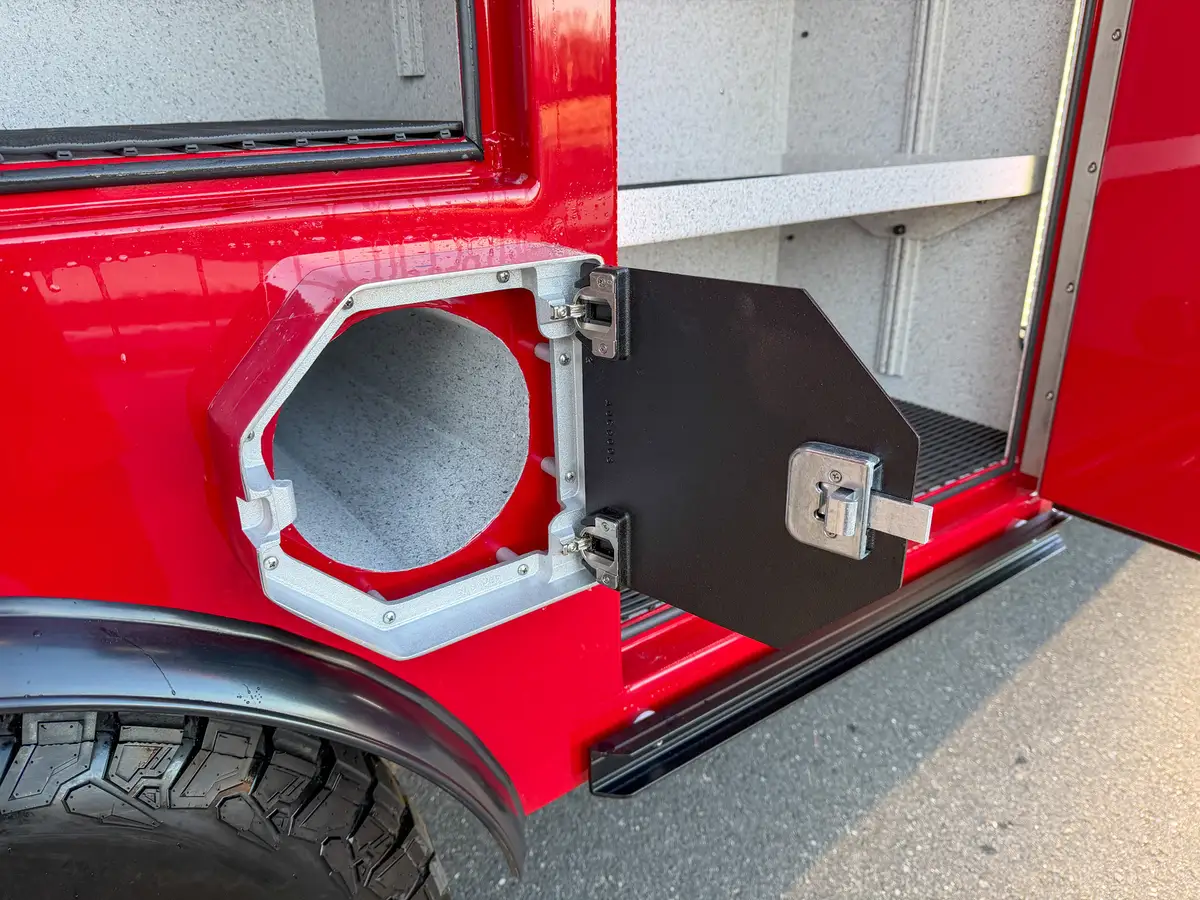 Alternate close-up of open round utility port and hinged cover.