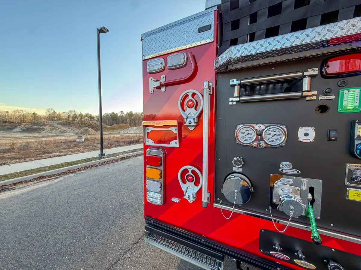 Left rear pump-panel area with fold-down grab bar in stowed position.
