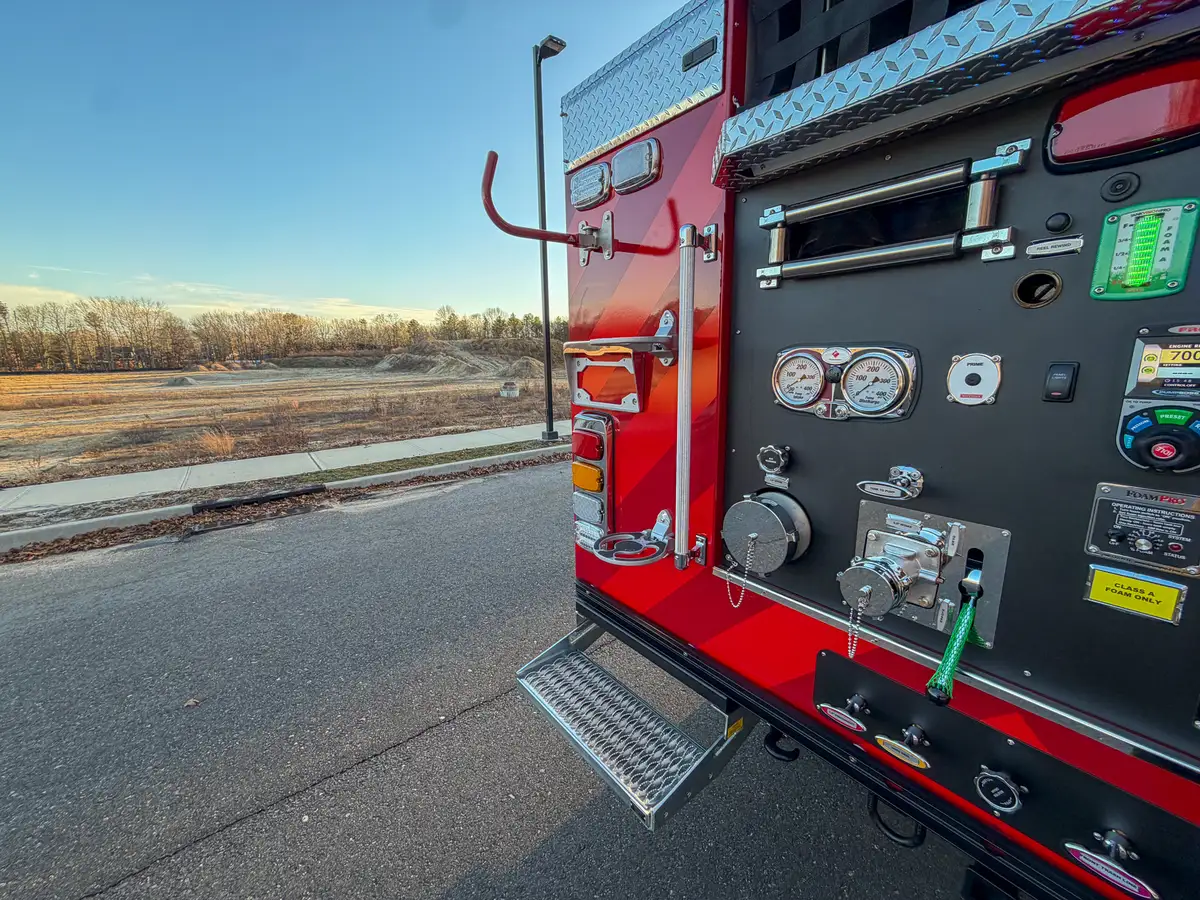 Left rear pump-panel area with grab bar extended and step deployed.