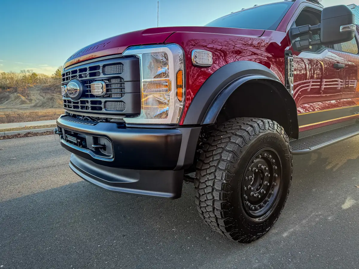 Front-right three-quarter close view showing grille, bumper, and front wheel.