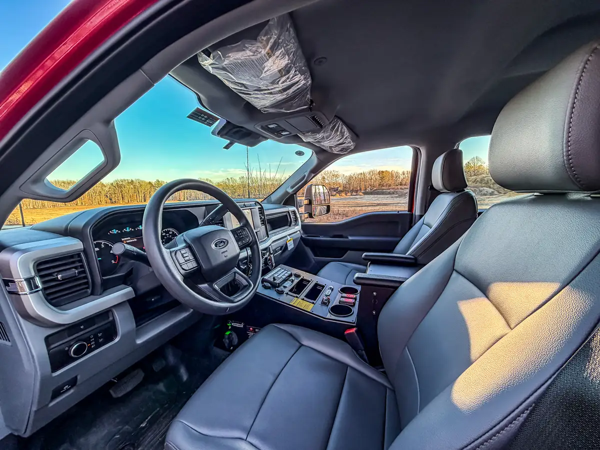 Wide interior view from driver side with front seats, dashboard, and center console.