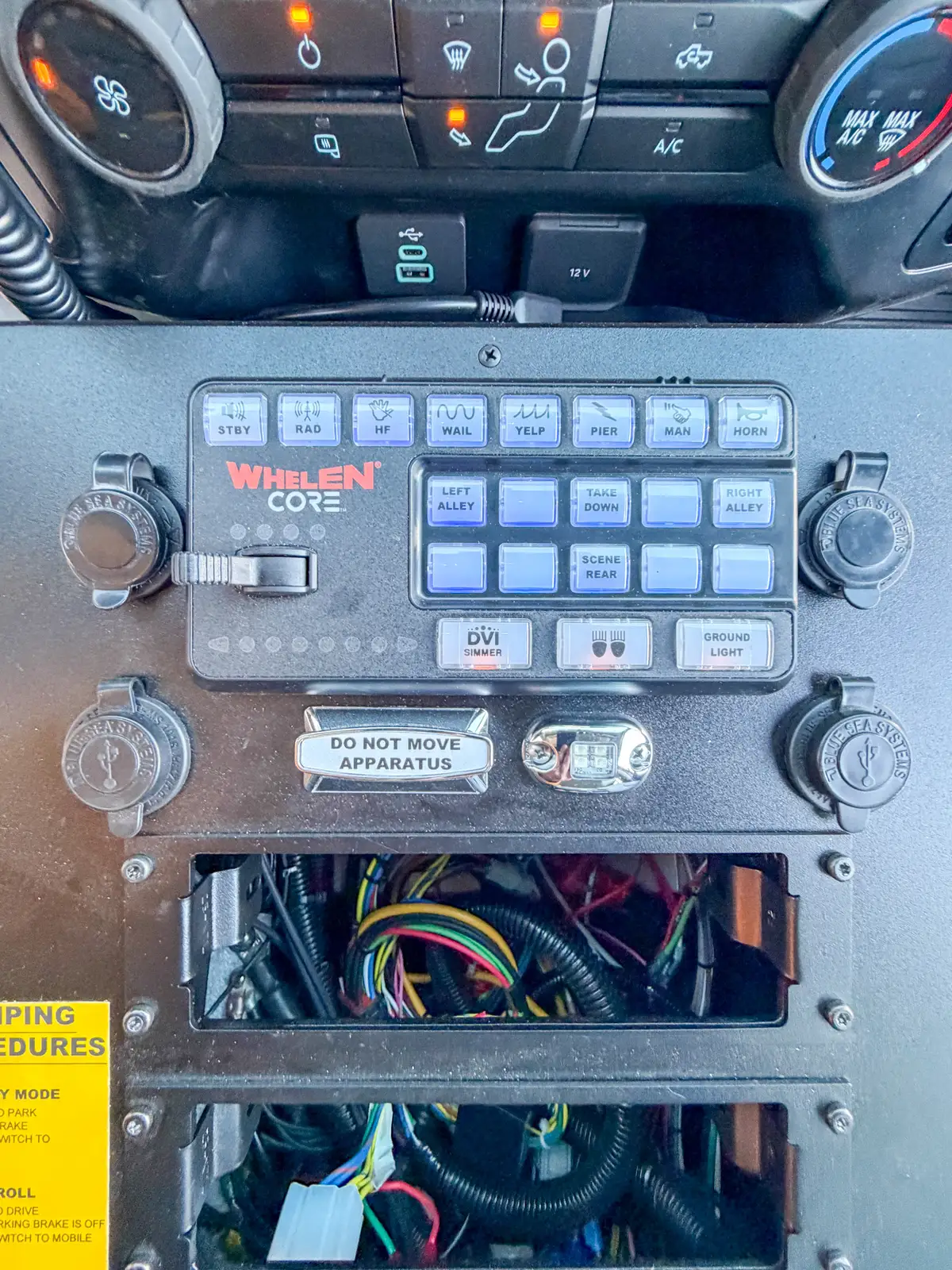 Close-up of console switch panel and keypad above open wiring access slots.