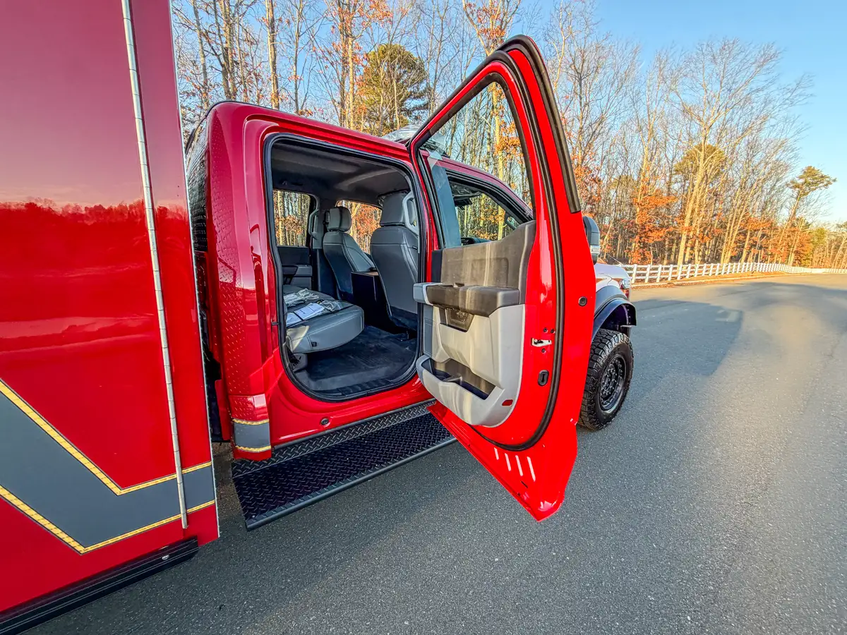 Passenger-side view with rear door open and rear bench seating visible.