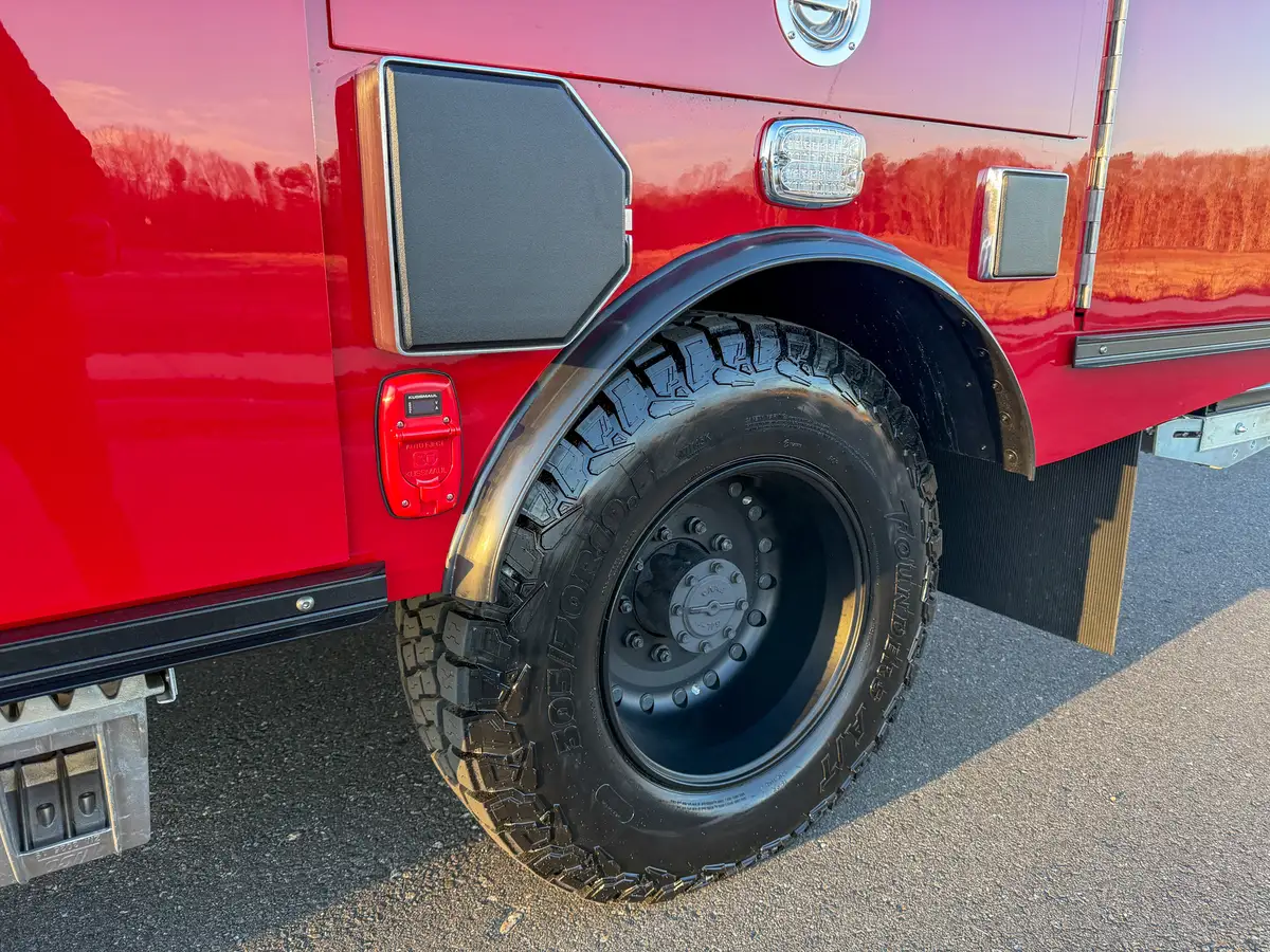 Rear side close-up showing wheel, fender, and lower side body compartments.