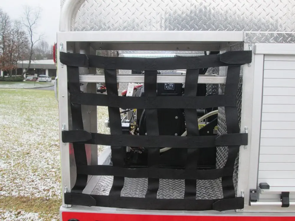 Exterior view of small fire truck showing cab, body compartments, and wheel/tire area.
