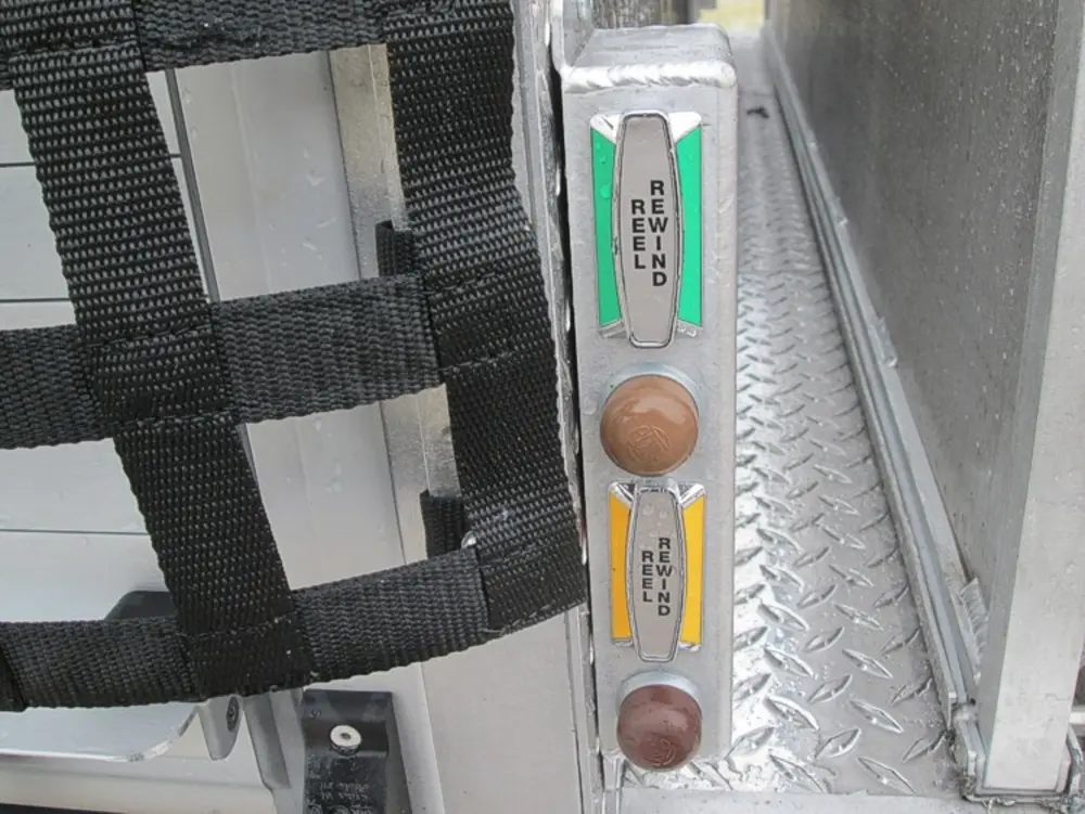 Exterior view of small fire truck showing cab, body compartments, and wheel/tire area.