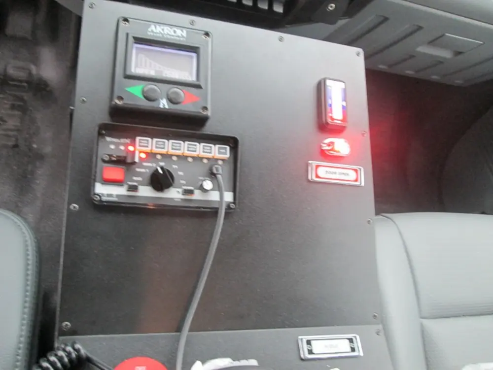 Exterior view of small fire truck showing cab, body compartments, and wheel/tire area.