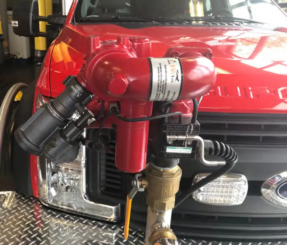 Exterior view of small fire truck showing cab, body compartments, and wheel/tire area.