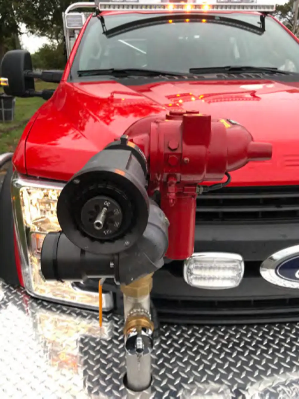 Exterior view of small fire truck showing cab, body compartments, and wheel/tire area.