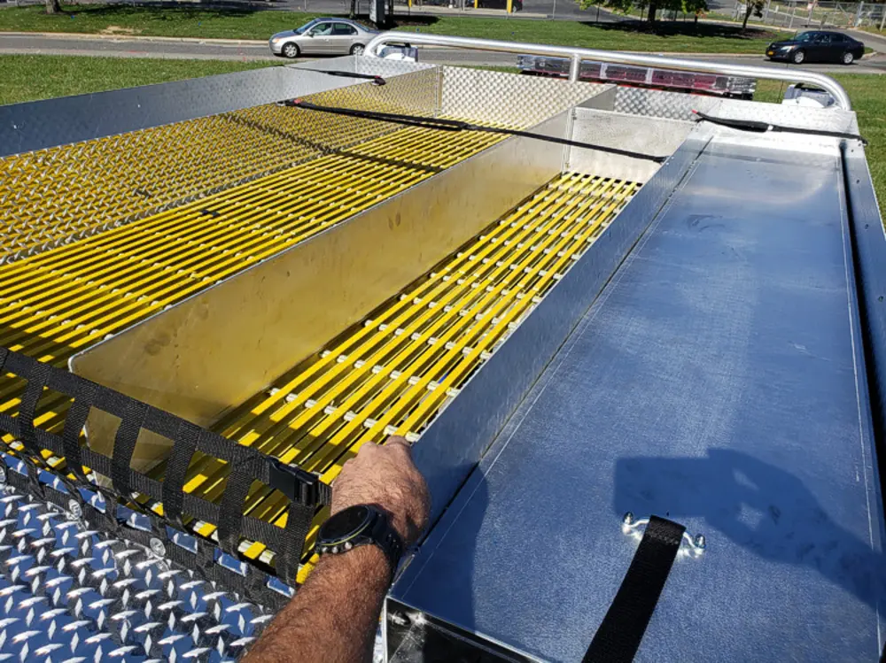 Exterior view of small fire truck showing cab, body compartments, and wheel/tire area.