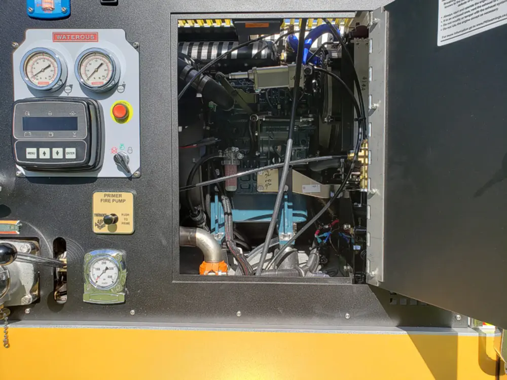 Exterior view of small fire truck showing cab, body compartments, and wheel/tire area.