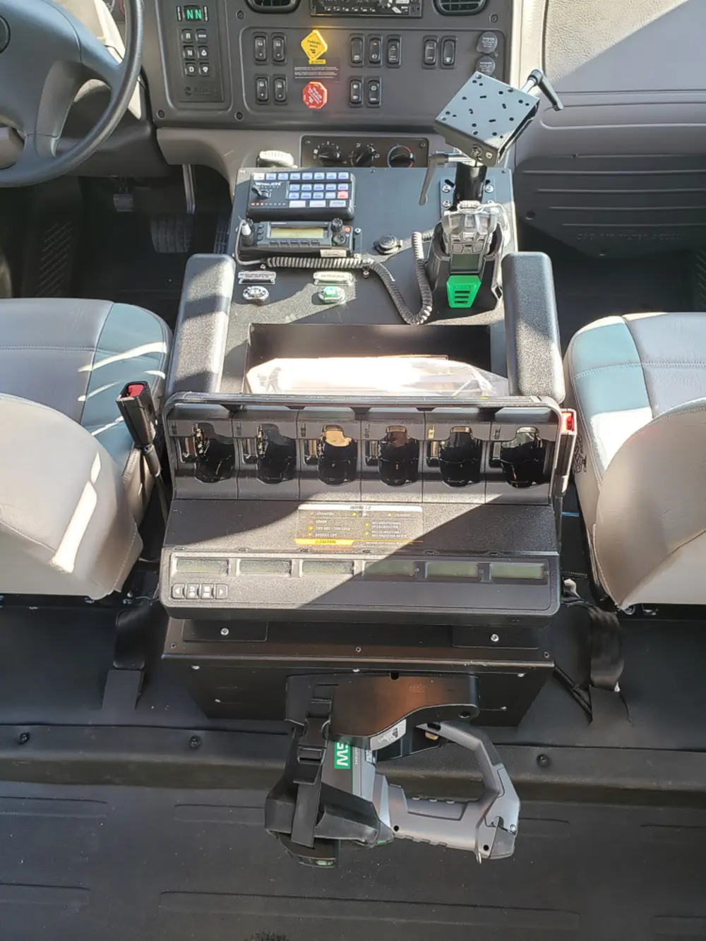 Exterior view of small fire truck showing cab, body compartments, and wheel/tire area.