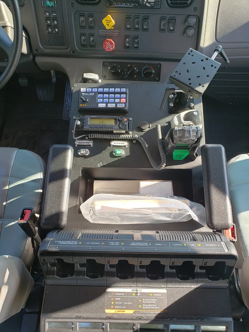 Exterior view of small fire truck showing cab, body compartments, and wheel/tire area.