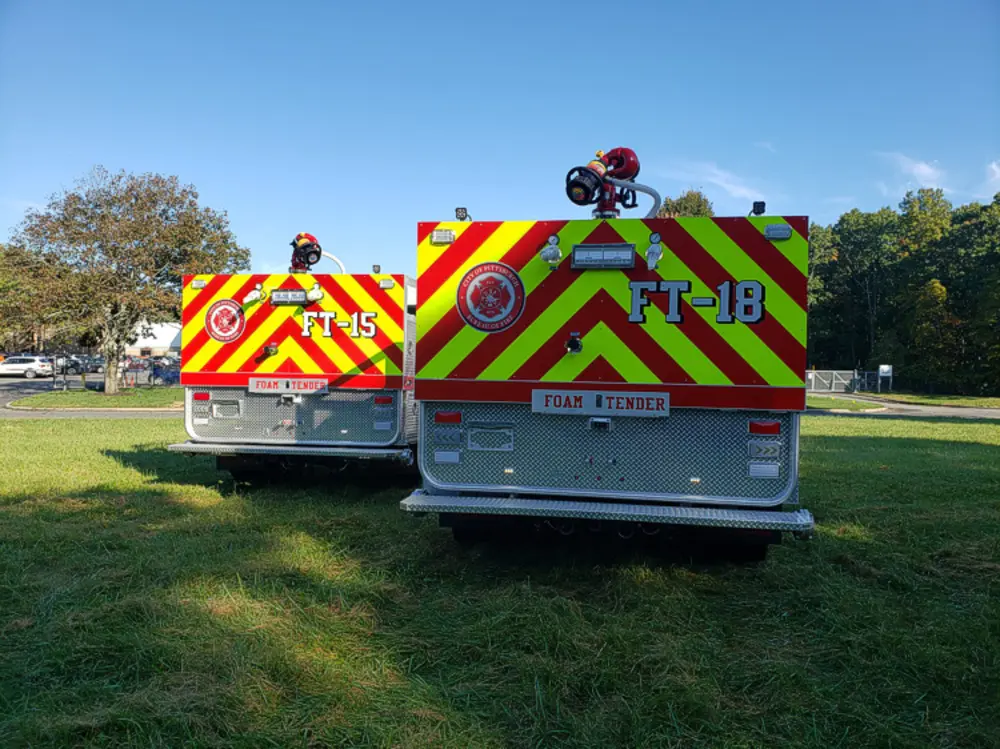 Exterior view of small fire truck showing cab, body compartments, and wheel/tire area.
