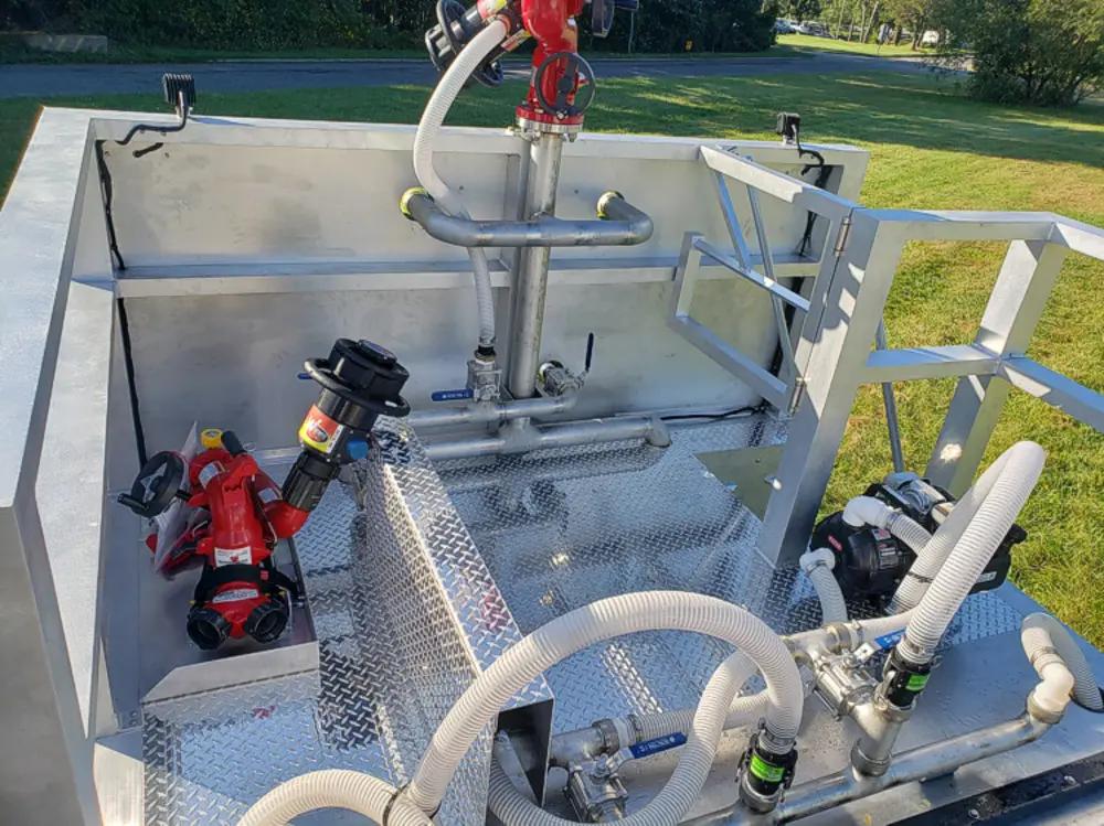 Exterior view of small fire truck showing cab, body compartments, and wheel/tire area.