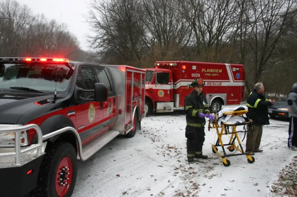 Exterior view of small fire truck showing cab, body compartments, and wheel/tire area.