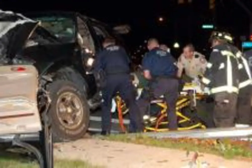 Exterior view of small fire truck showing cab, body compartments, and wheel/tire area.
