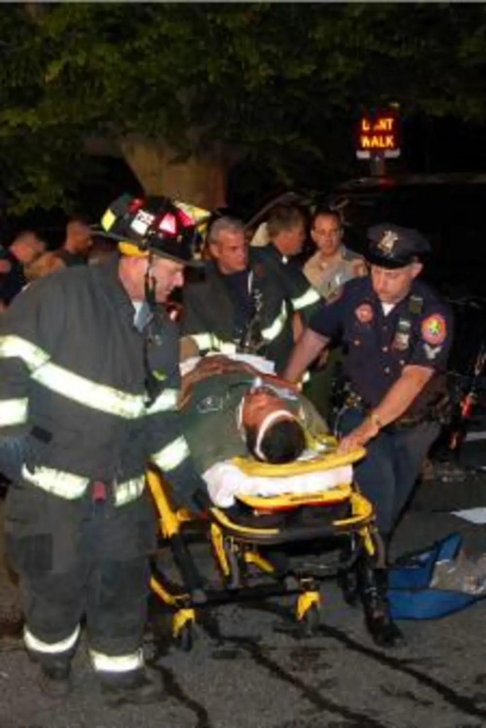 Exterior view of small fire truck showing cab, body compartments, and wheel/tire area.
