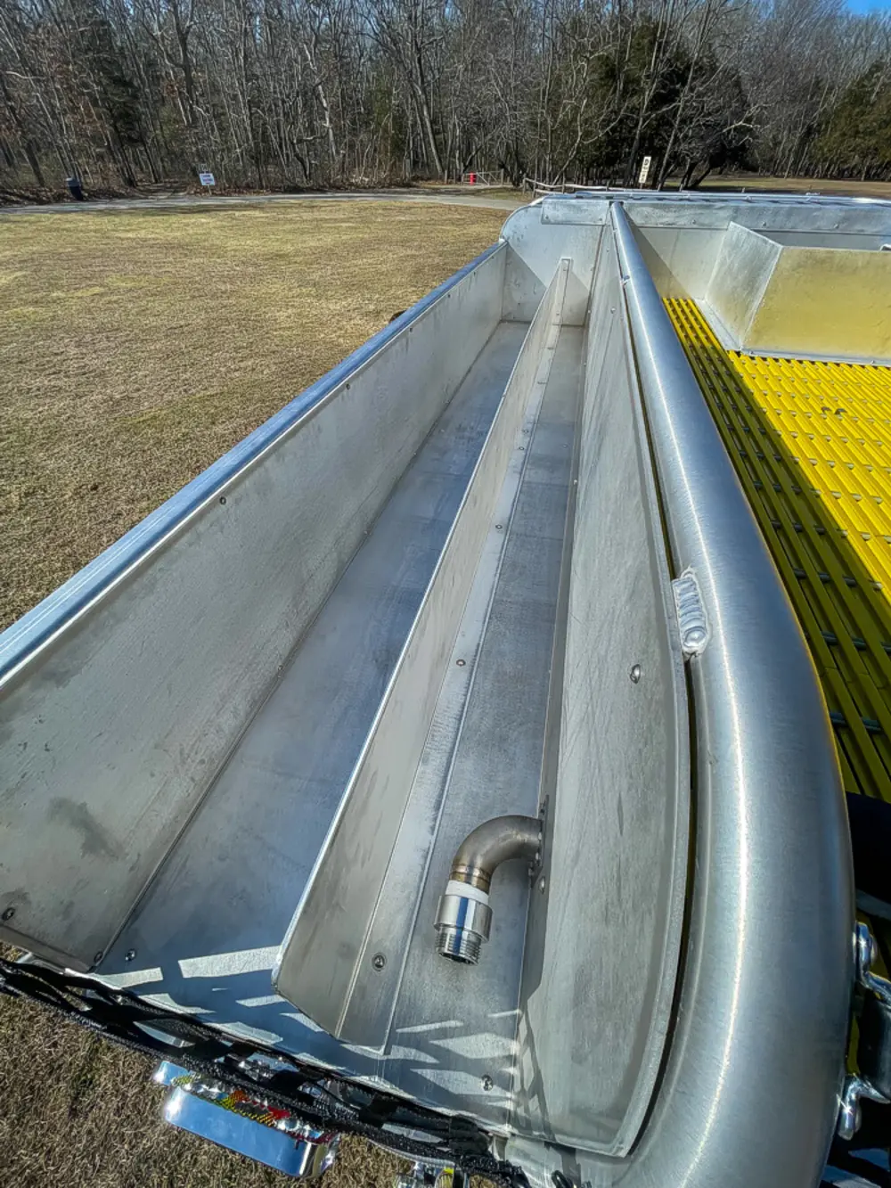Exterior view of small fire truck showing cab, body compartments, and wheel/tire area.