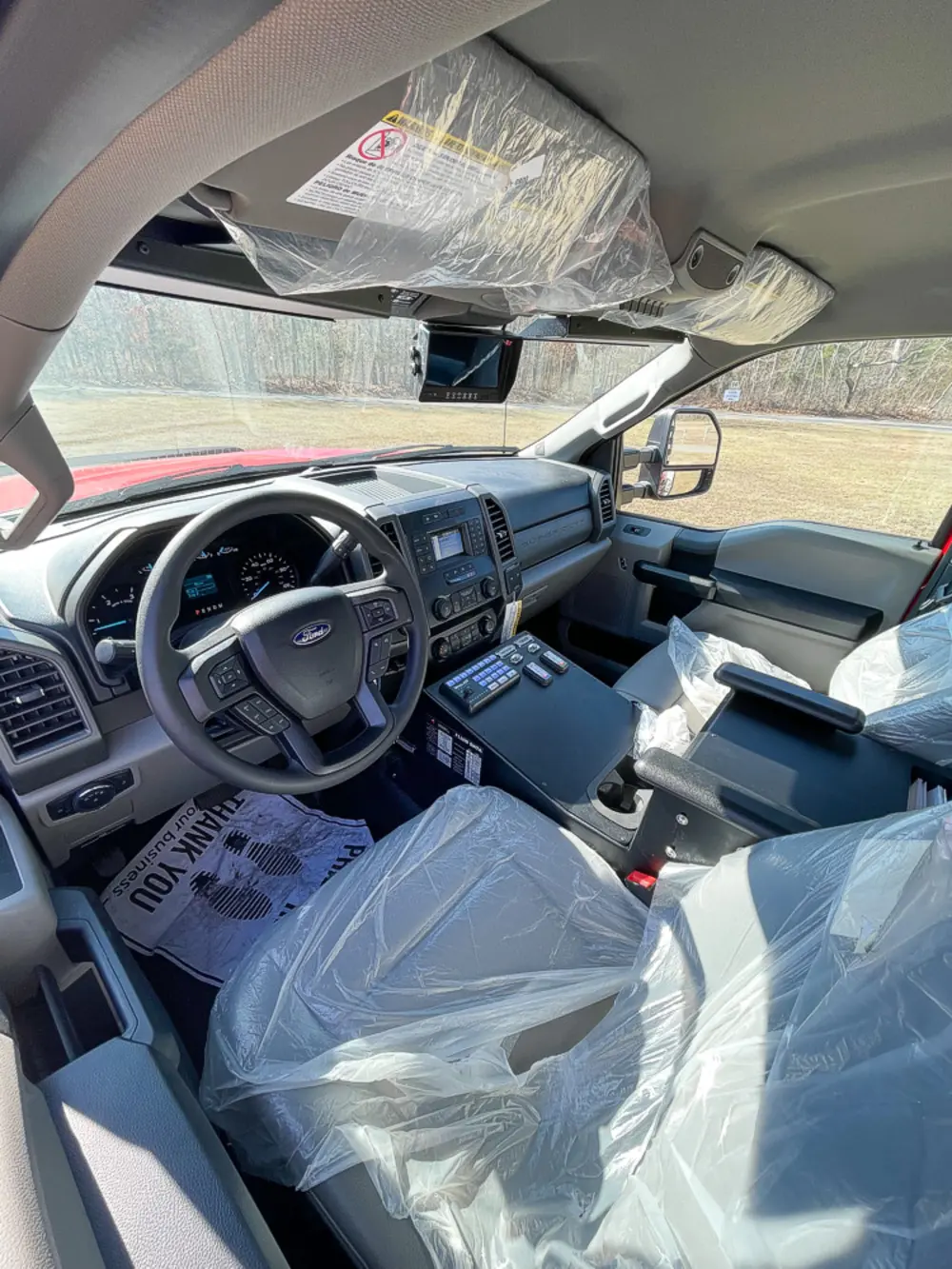 Exterior view of small fire truck showing cab, body compartments, and wheel/tire area.