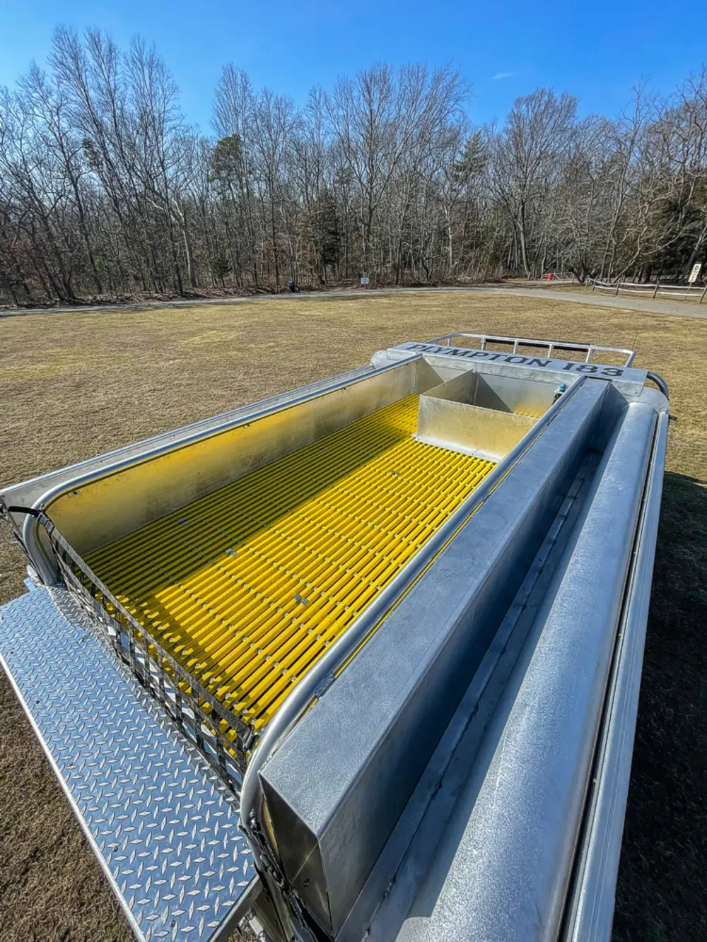 Exterior view of small fire truck showing cab, body compartments, and wheel/tire area.