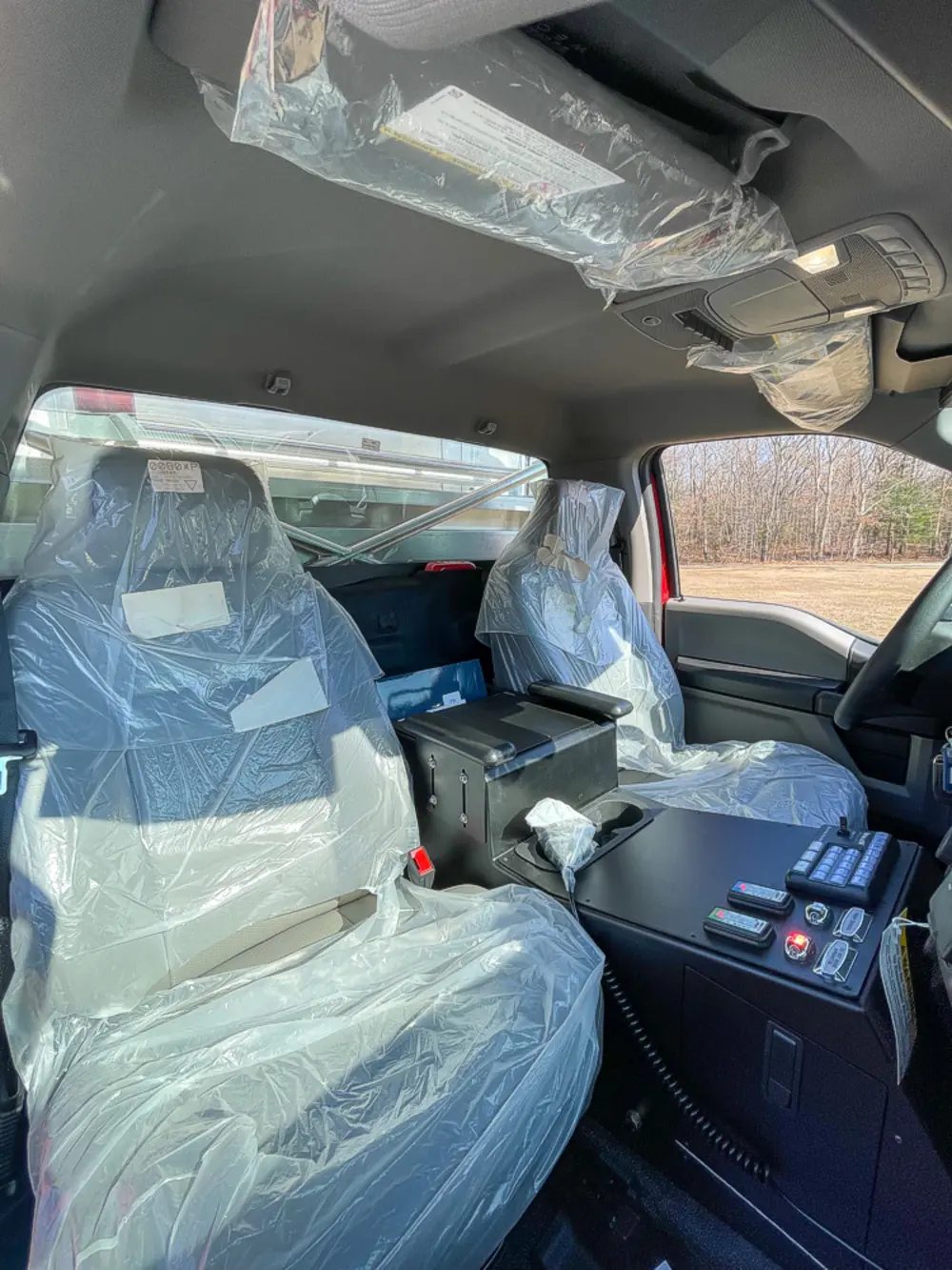 Exterior view of small fire truck showing cab, body compartments, and wheel/tire area.