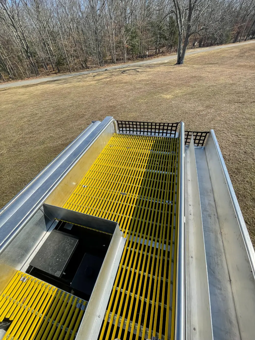 Exterior view of small fire truck showing cab, body compartments, and wheel/tire area.