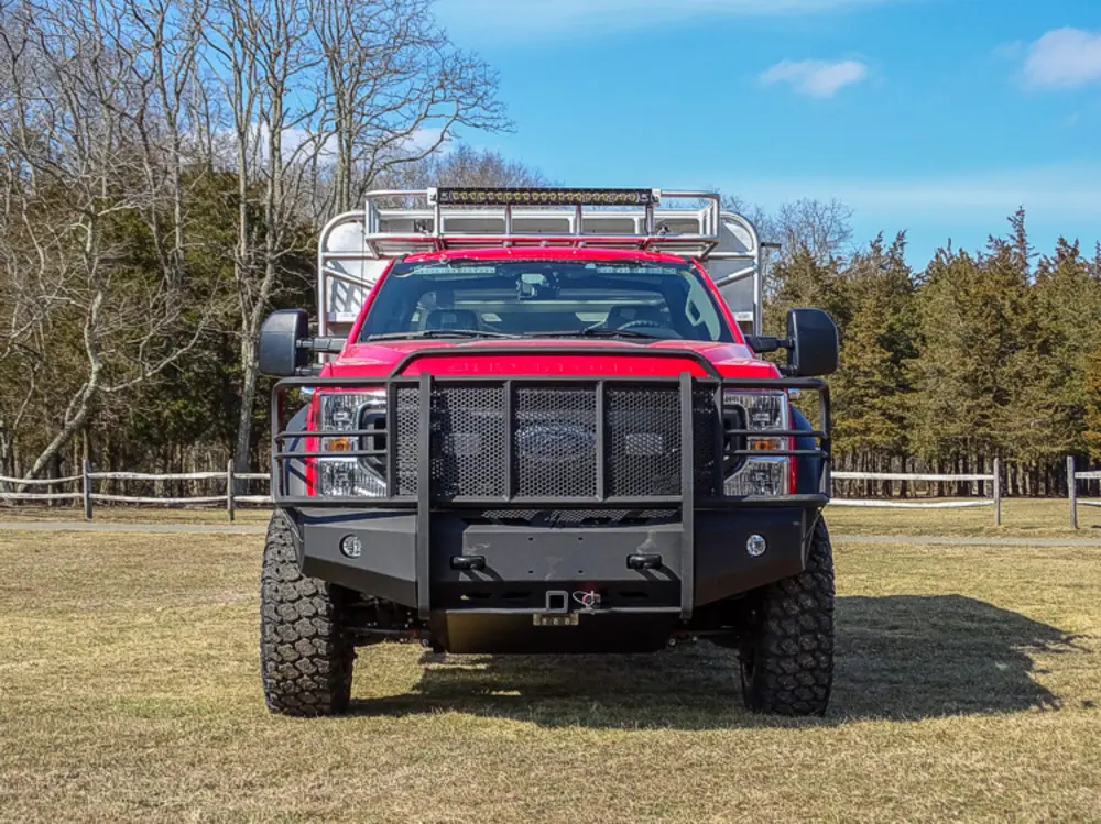 Exterior view of small fire truck showing cab, body compartments, and wheel/tire area.
