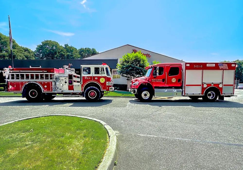 Exterior view of small fire truck showing cab, body compartments, and wheel/tire area.