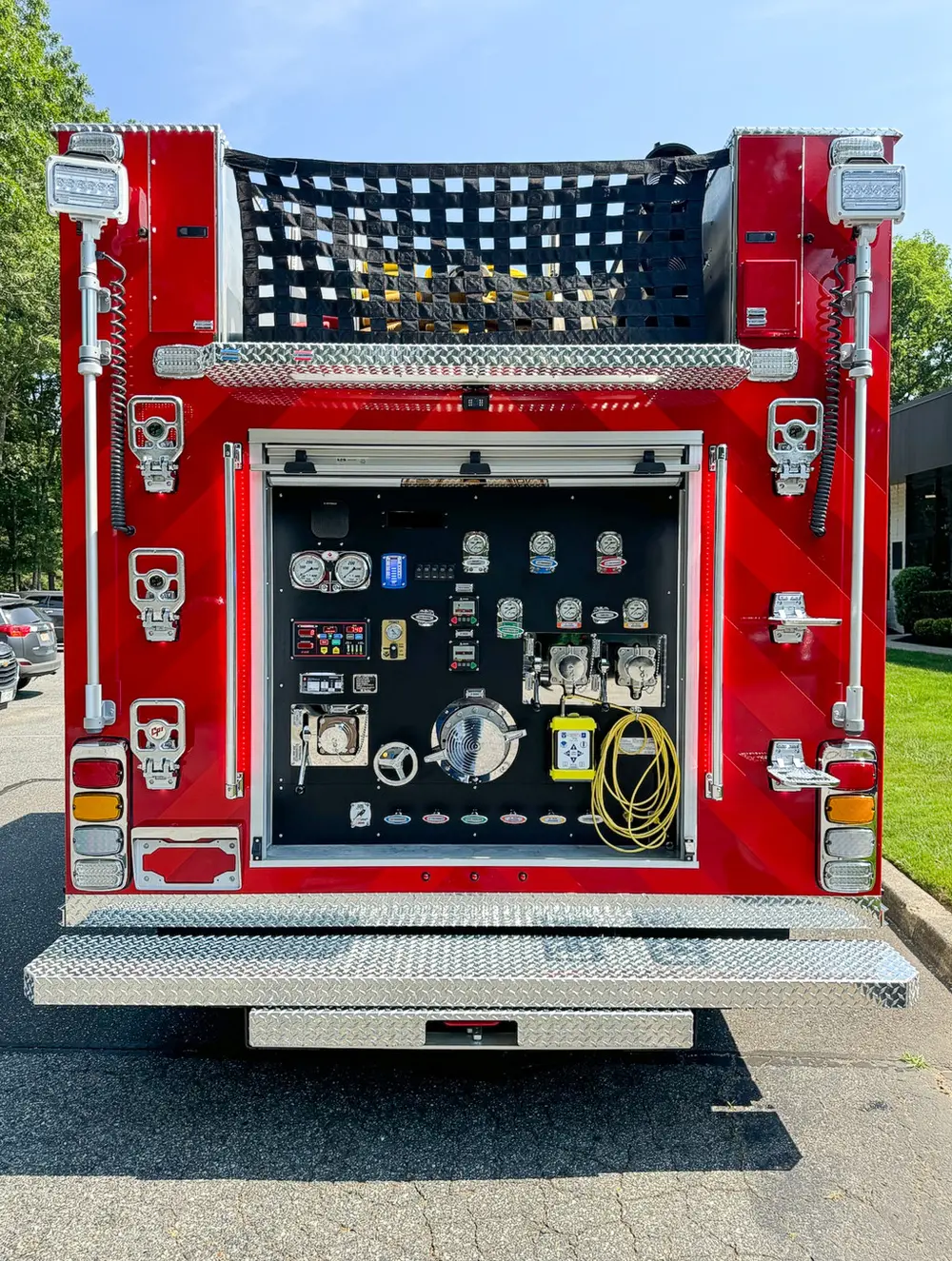 Exterior view of small fire truck showing cab, body compartments, and wheel/tire area.