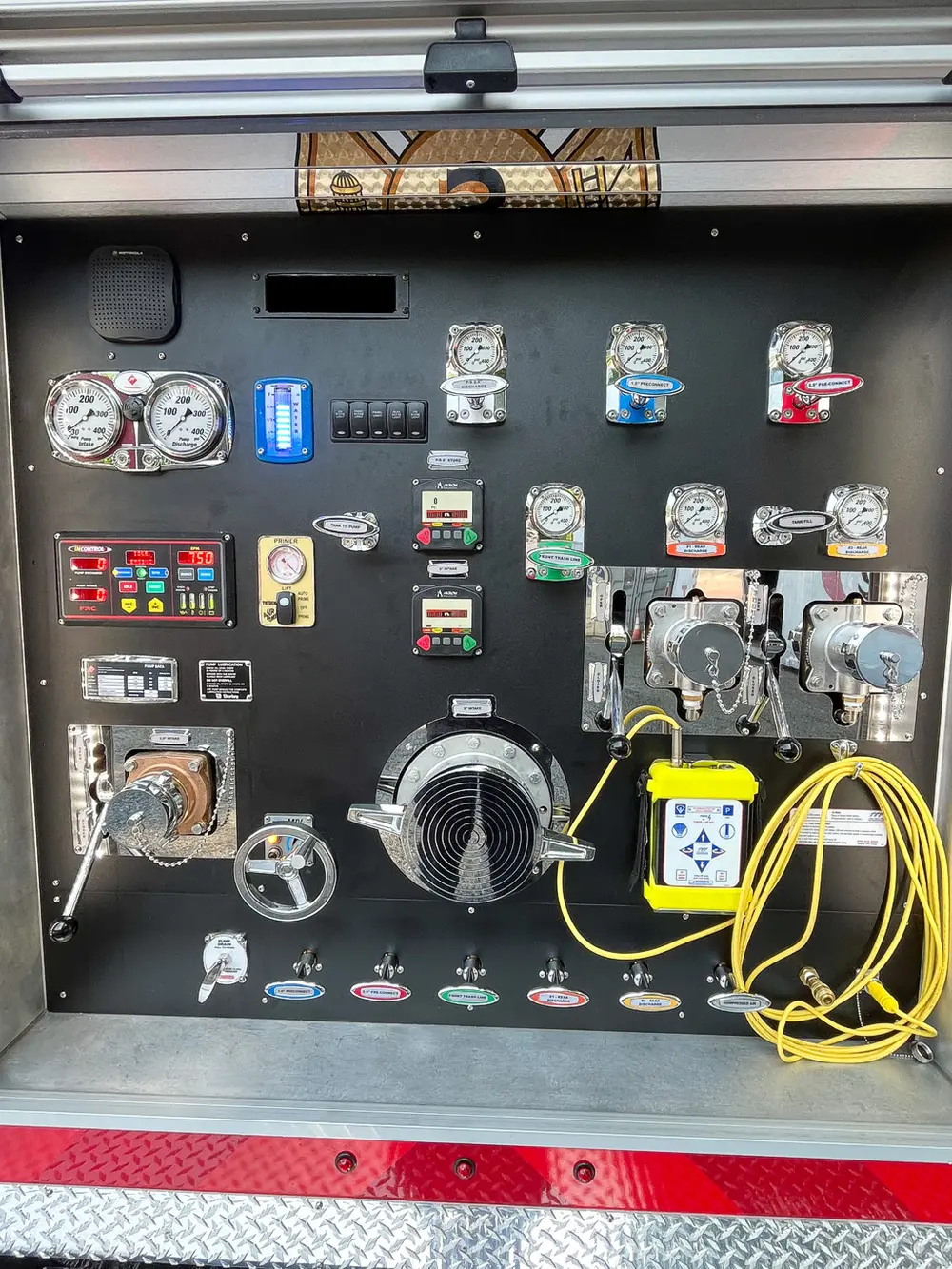 Exterior view of small fire truck showing cab, body compartments, and wheel/tire area.