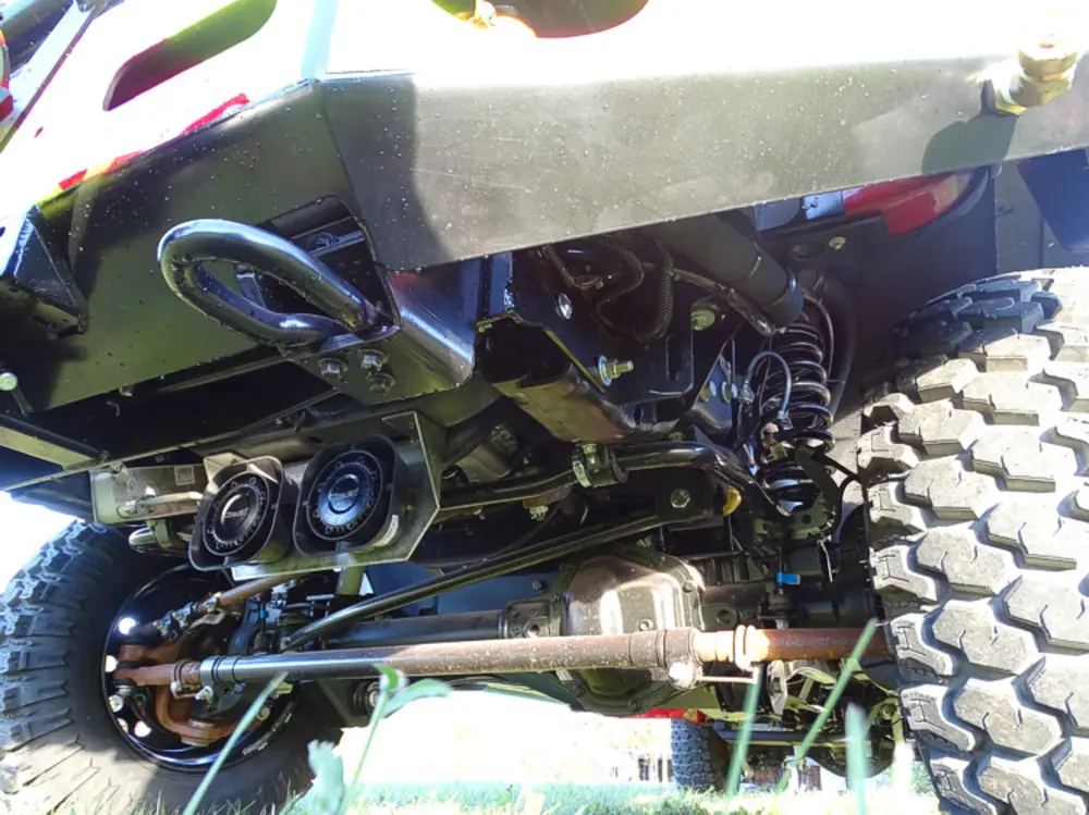 Exterior view of small fire truck showing cab, body compartments, and wheel/tire area.