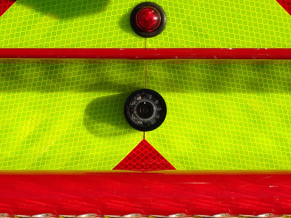 Exterior view of small fire truck showing cab, body compartments, and wheel/tire area.