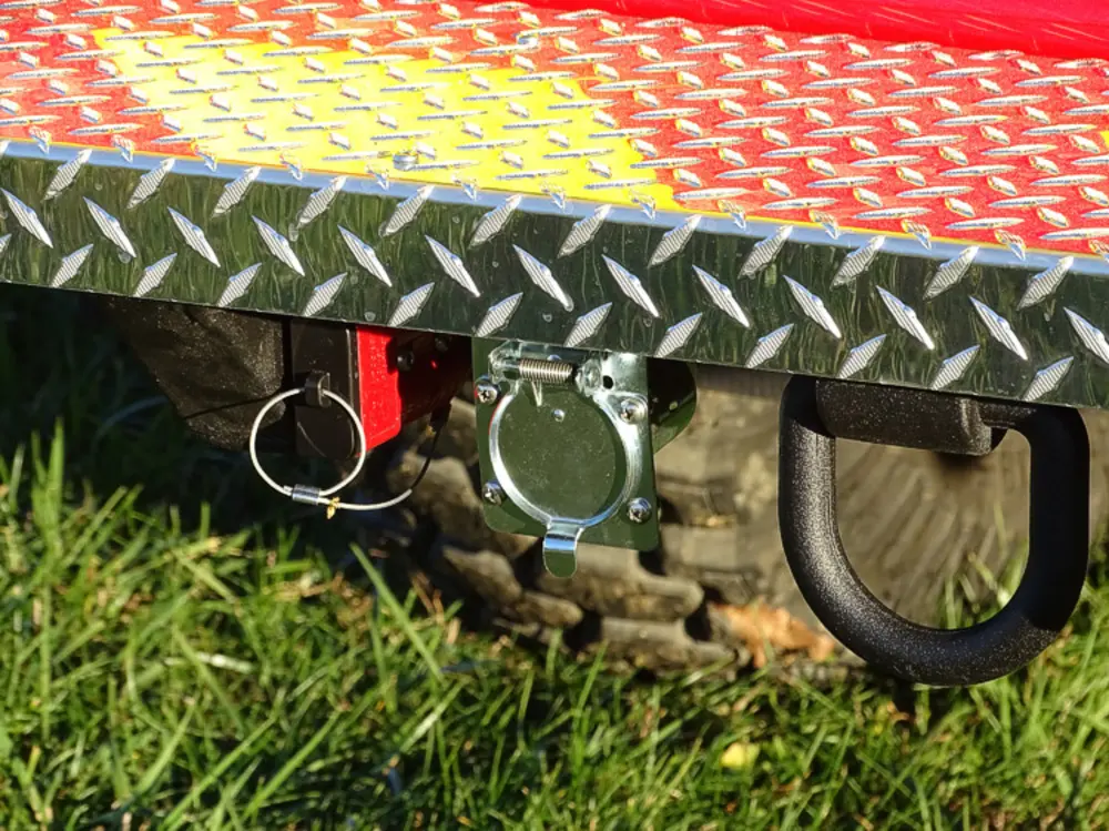 Exterior view of small fire truck showing cab, body compartments, and wheel/tire area.