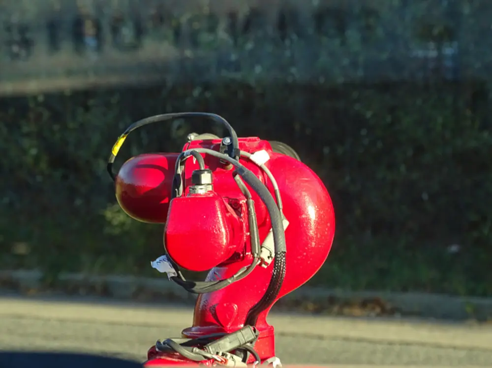 Exterior view of small fire truck showing cab, body compartments, and wheel/tire area.
