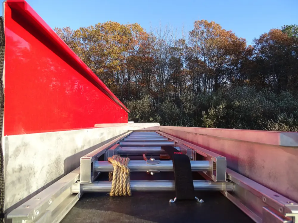 Exterior view of small fire truck showing cab, body compartments, and wheel/tire area.
