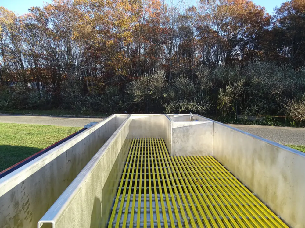 Exterior view of small fire truck showing cab, body compartments, and wheel/tire area.