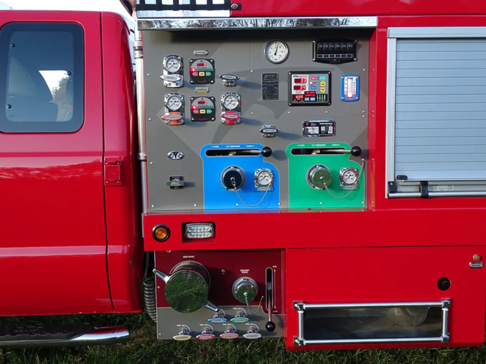 Exterior view of small fire truck showing cab, body compartments, and wheel/tire area.
