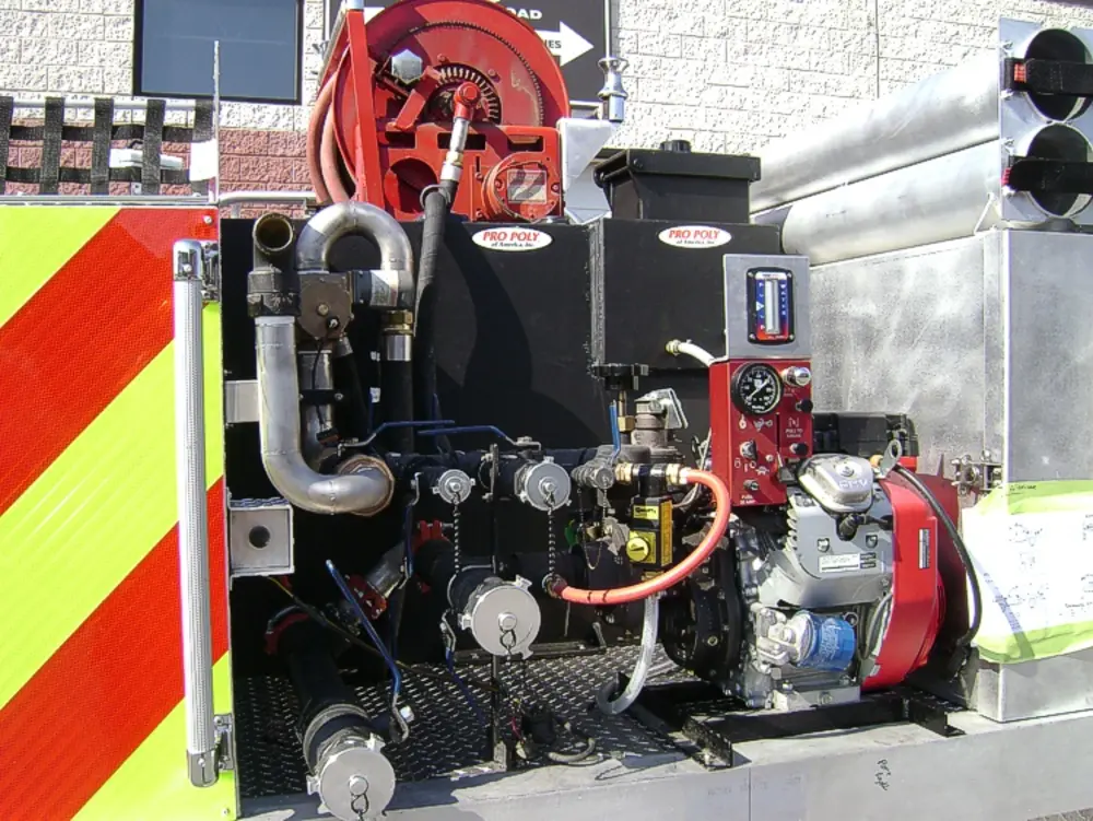 Exterior view of small fire truck showing cab, body compartments, and wheel/tire area.