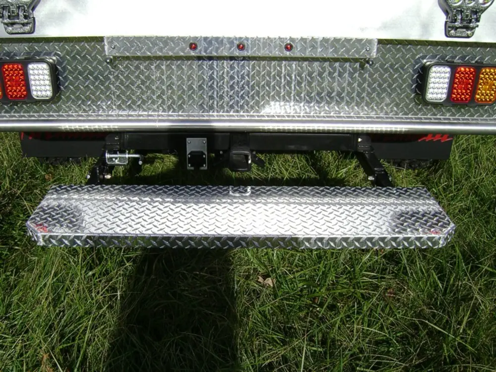 Exterior view of small fire truck showing cab, body compartments, and wheel/tire area.
