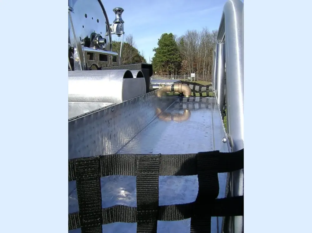 Exterior view of small fire truck showing cab, body compartments, and wheel/tire area.