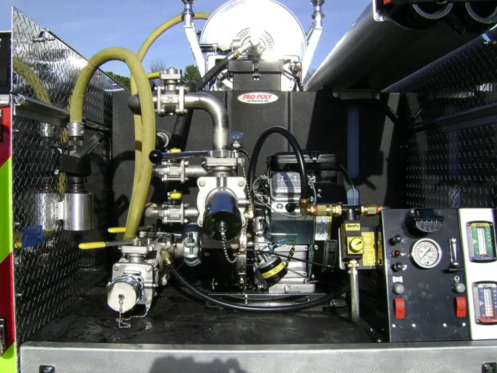 Exterior view of small fire truck showing cab, body compartments, and wheel/tire area.