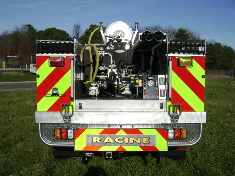 Exterior view of small fire truck showing cab, body compartments, and wheel/tire area.