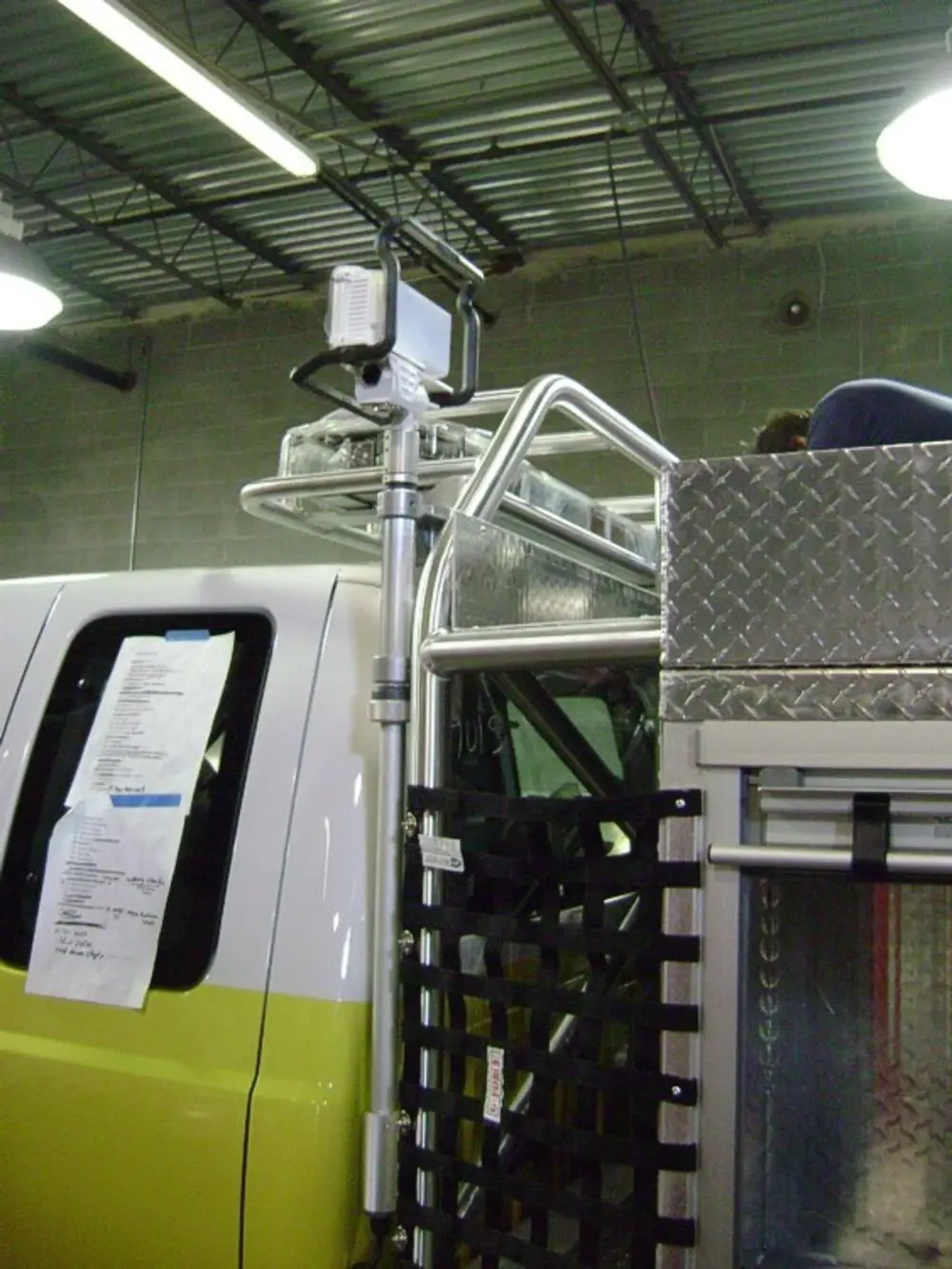 Exterior view of small fire truck showing cab, body compartments, and wheel/tire area.