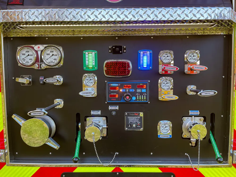 Exterior view of small fire truck showing cab, body compartments, and wheel/tire area.