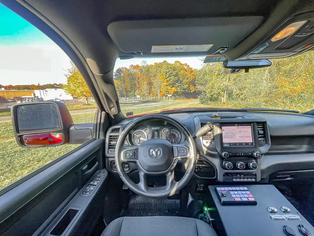 Exterior view of small fire truck showing cab, body compartments, and wheel/tire area.